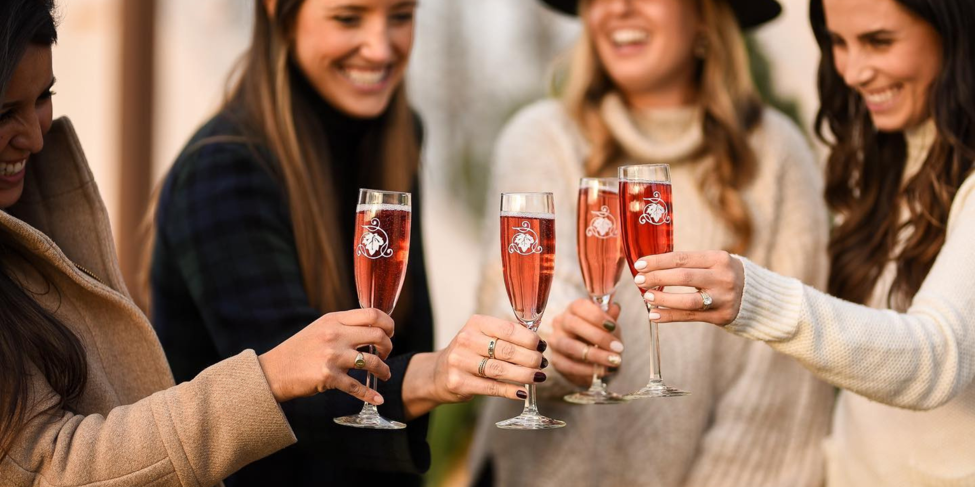 Holiday Gift of Memories Blog 4 women in winter attire stand together, clinking their wine glasses at Potomac Point Winery